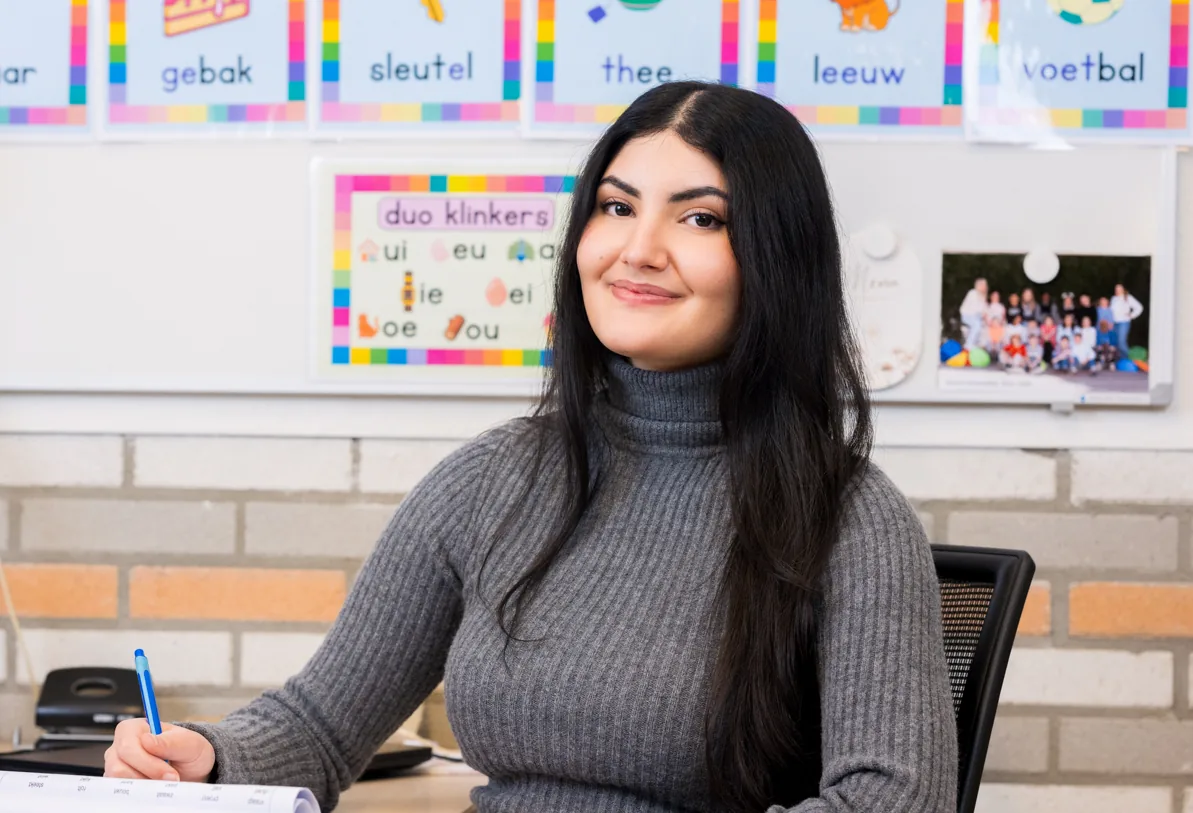 Leerkracht aan haar bureau in de klas